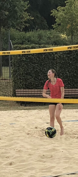 Beachvolleyball Feld mit zwei jungen Spielerinnen.