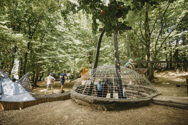 Kinder spielen auf dem Waldspielplatz im Sauerlandpark, mitten im Wald.